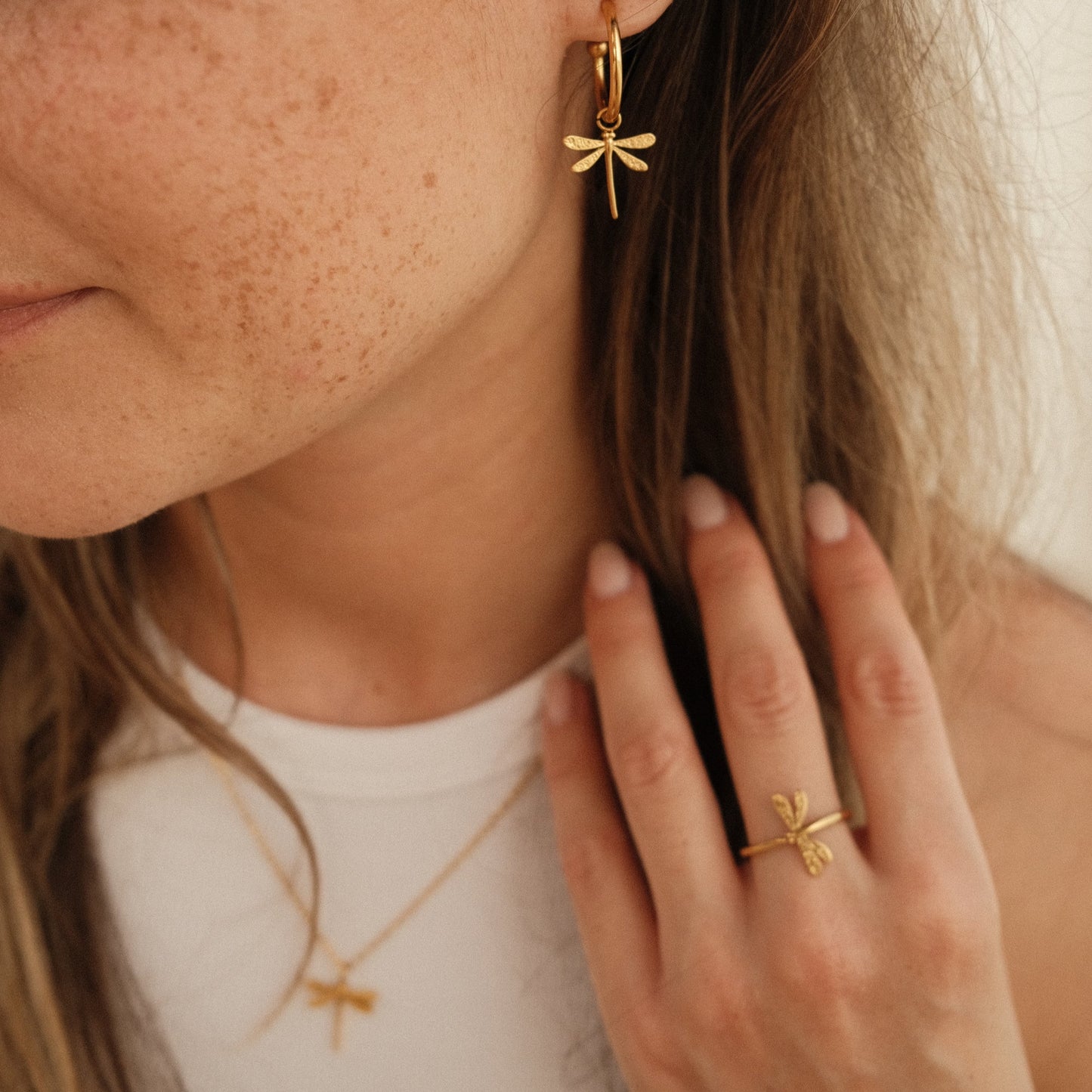gold dragonfly earrings on the model