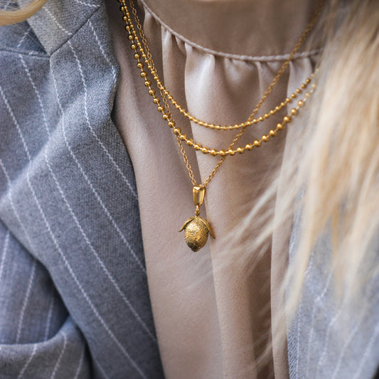 Gold-plated stainless steel chain with stylish lemon pendant - hypoallergenic & robust.