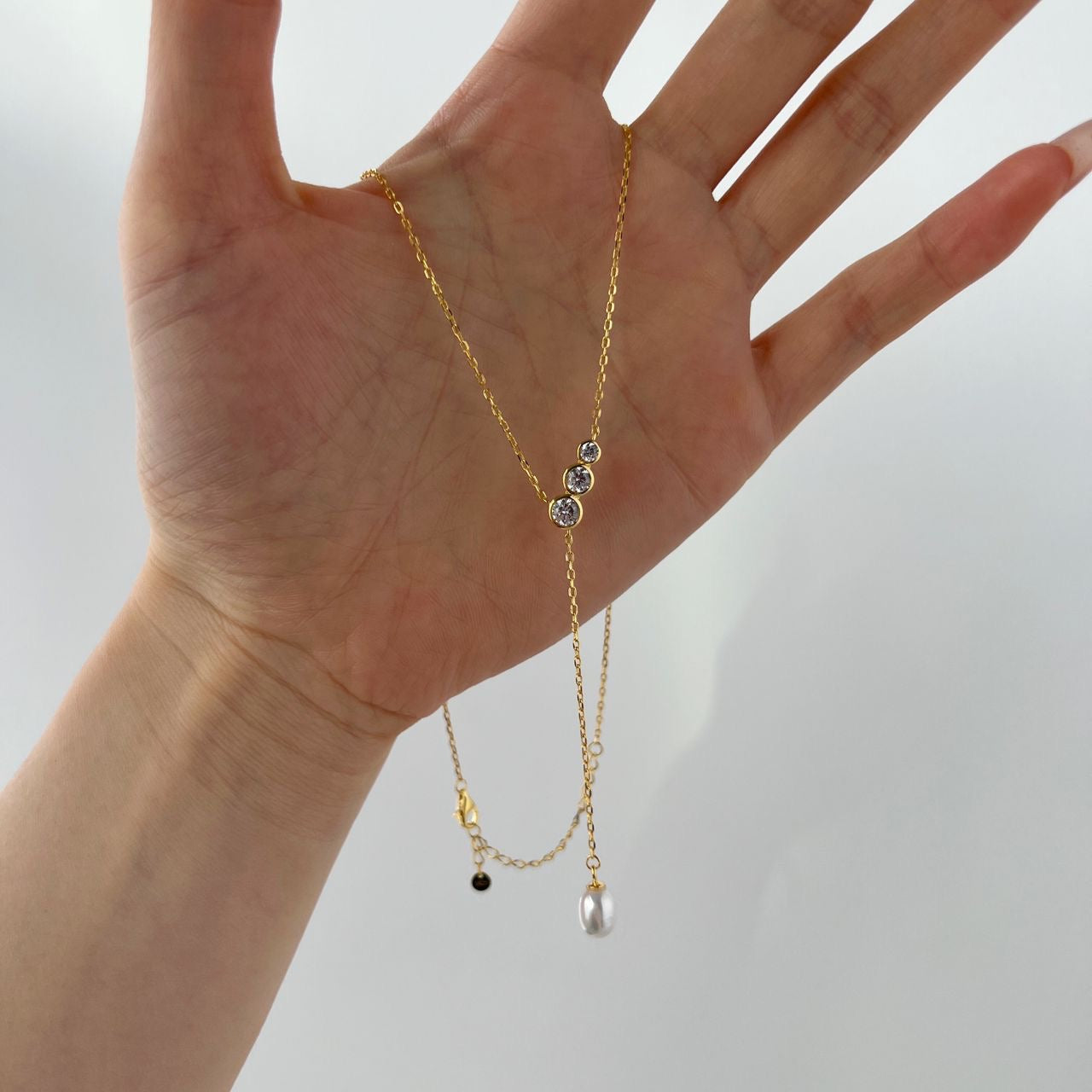 Detailed view of the pearl and zirconia of the Lariat bridal necklace "Tiffany", gold.